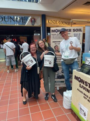 Growers holding Monster Soil Pots at the Monster Soil stand at a trade fair